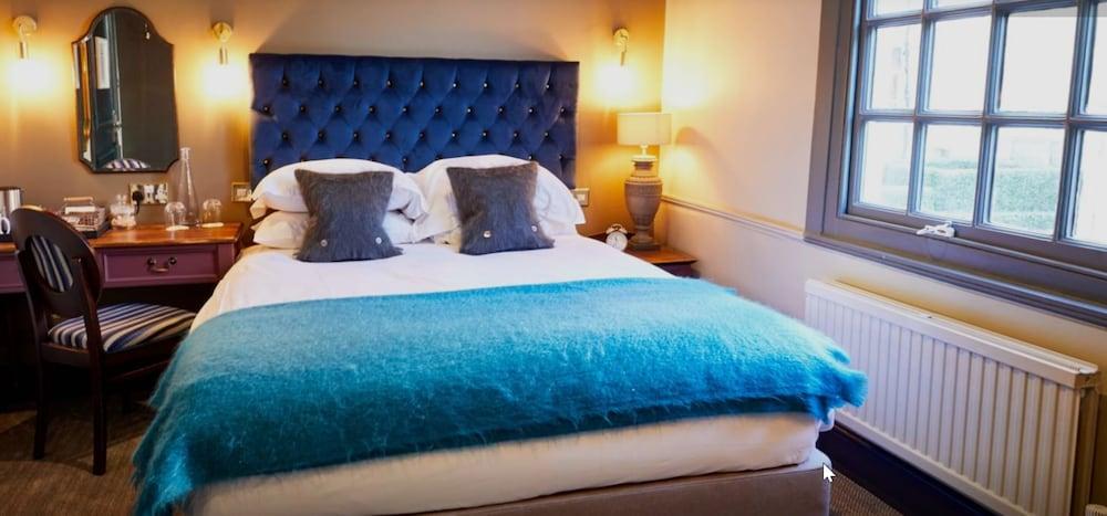 The Fleece At Cirencester Eksteriør bilde A bed with a blue throw